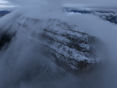 Aerial view of the snow capped Pyrenees mountain peak partially obscured by thick clouds in Spain. Aerial view of the snow capped Pyrenees mountain peak partially obscured by thick clouds in Spain.