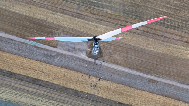 Aerial view of a damaged wind turbine with broken blades and debris scattered on the ground in the middle of agricultural fields in Vladimirovac Vojvodina Serbia.