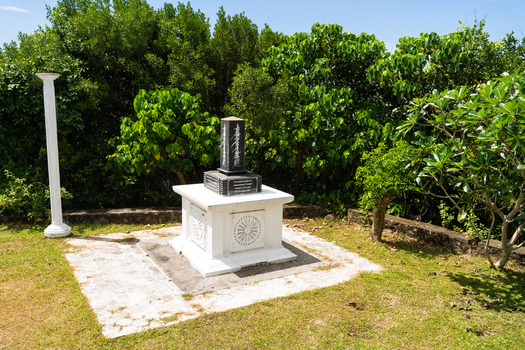 View of the Japanese Peace Pagoda Rumassala monument with a black pillar and white base surrounded by lush green trees in Unawatuna Southern Province Sri Lanka. View of the Japanese Peace Pagoda Rumassala monument with a black pillar and white base surrounded by lush green trees in Unawatuna Southern Province Sri Lanka.