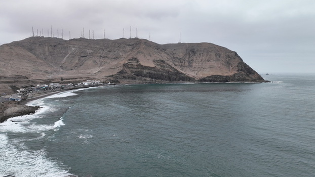 Aerial view of the rocky coastline and cliffs of Barranco with crashing waves and a cloudy sky in Barranco Lima Province Peru.