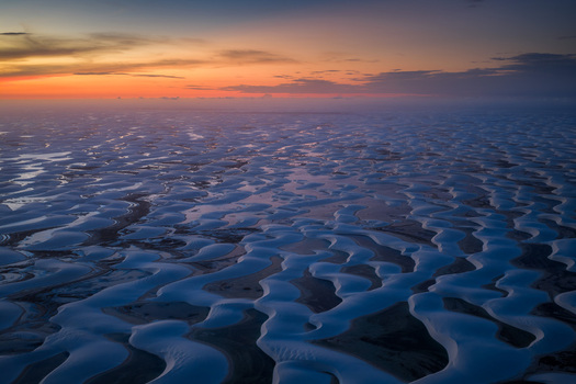 Aerial view of the white sand dunes and lagoons of Parque Nacional dos Lencois Maranhenses under a sunset sky in Lencois Maranhenses MA Brazil. Aerial view of the white sand dunes and lagoons of Parque Nacional dos Lencois Maranhenses under a sunset sky in Lencois Maranhenses MA Brazil.