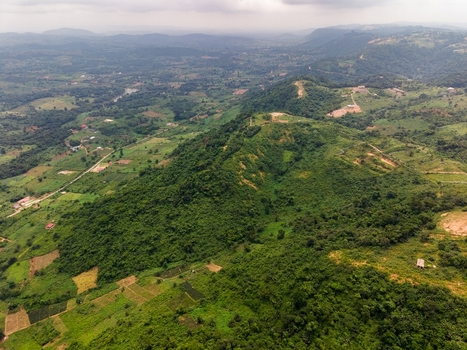 Aerial view of lush green rolling hills and agricultural farmland in the countryside of Ghana. Aerial view of lush green rolling hills and agricultural farmland in the countryside of Ghana.