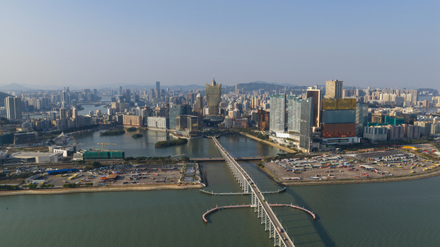 Macao 18 February 2026 Aerial view of the Macau skyline featuring the Grand Lisboa hotel modern skyscrapers and the Sai Van Bridge spanning the water under a clear sky. Macao 18 February 2026 Aerial view of the Macau skyline featuring the Grand Lisboa hotel modern skyscrapers and the Sai Van Bridge spanning the water under a clear sky.