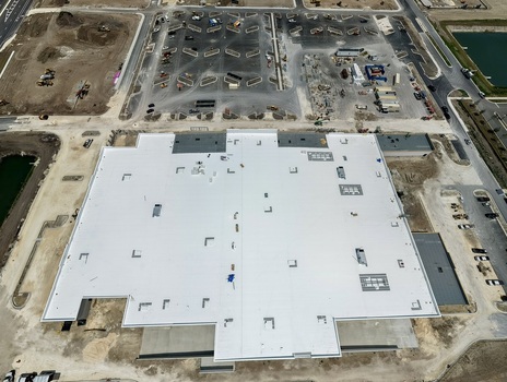 Aerial view of the large white roof of a commercial building under construction at Foundry Lane with surrounding parking lots World Golf Village Florida United States.