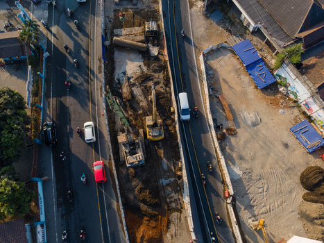 Aerial view of road construction site with excavators working on a busy street in Yogyakarta Special Region of Yog Indonesia. Aerial view of road construction site with excavators working on a busy street in Yogyakarta Special Region of Yog Indonesia.