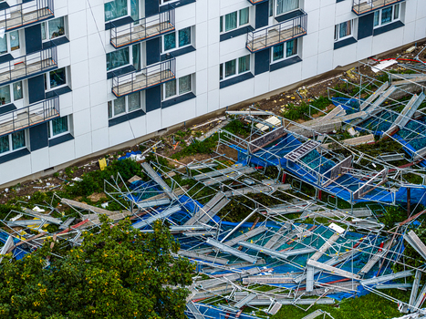 Riga Latvia 23 August 2026 Aerial view of collapsed scaffolding structure lying on the ground next to a modern apartment building.