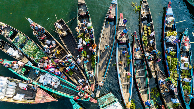 Rangamati Bangladesh 19 October 2022 Aerial view of wooden boats filled with produce and people navigating the waterway.