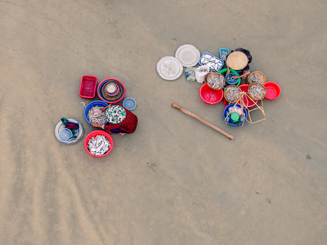 Aerial view of two women sorting fresh fish in colorful plastic basins on a sandy beach in Vietnam. Aerial view of two women sorting fresh fish in colorful plastic basins on a sandy beach in Vietnam.