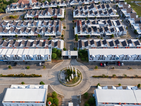 Aerial view of a modern residential housing complex with uniform white houses and a central roundabout in Semarang Central Java Indonesia. Aerial view of a modern residential housing complex with uniform white houses and a central roundabout in Semarang Central Java Indonesia.