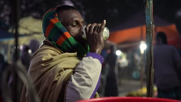 View of a man drinking from a glass at a night market Bangladesh. View of a man drinking from a glass at a night market Bangladesh.
