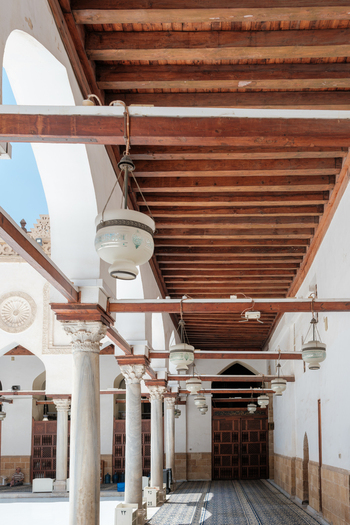View of the historic marble columns and ornate wooden ceiling with hanging lanterns at Al Azhar Mosque in Cairo Egypt. View of the historic marble columns and ornate wooden ceiling with hanging lanterns at Al Azhar Mosque in Cairo Egypt.
