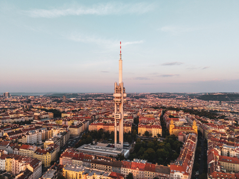 Aerial view of Zizkov Television Tower rising above the historic rooftops and urban landscape of Prague Prague Czechia.