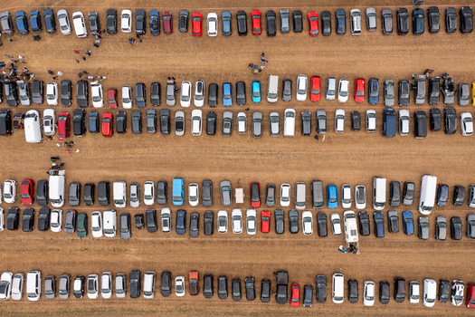 Aerial view of the Open Beatz Festival parking lot with rows of colorful cars and people walking on a dirt field in Herzogenaurach Bayern Germany. Aerial view of the Open Beatz Festival parking lot with rows of colorful cars and people walking on a dirt field in Herzogenaurach Bayern Germany.