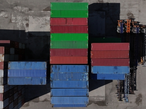 Aerial view of colorful shipping containers stacked in an industrial port terminal under bright sunlight Cincinnati OH United States.