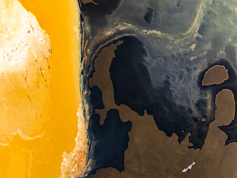 Aerial view of the dramatic coastline showing a striking contrast between vibrant yellow geothermal sediment and deep dark ocean waters in Reykjanesbaer Iceland. Aerial view of the dramatic coastline showing a striking contrast between vibrant yellow geothermal sediment and deep dark ocean waters in Reykjanesbaer Iceland.