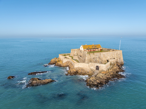 Aerial view of a formidable stone fort standing resilient against the turquoise sea its yellow roofed building a beacon under the clear sky Fort National Saint Malo Brittany France. Aerial view of a formidable stone fort standing resilient against the turquoise sea its yellow roofed building a beacon under the clear sky Fort National Saint Malo Brittany France.
