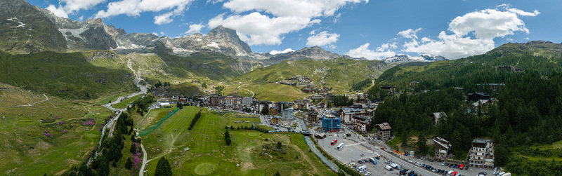Aerial view of the mountain resort of Breuil Cervinia nestled in green alpine meadows with the Matterhorn peak in the background Breuil Cervinia Aosta Valley Italy. Aerial view of the mountain resort of Breuil Cervinia nestled in green alpine meadows with the Matterhorn peak in the background Breuil Cervinia Aosta Valley Italy.