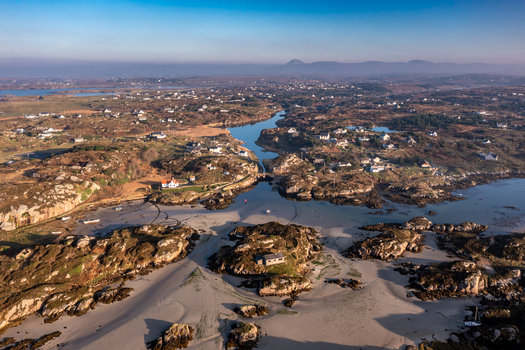 Aerial view of Kincasslagh a coastal village in County Donegal Ireland featuring rugged rocky terrain sandy beaches scattered houses and a winding inlet. Kincasslagh County Donegal Ireland. Aerial view of Kincasslagh a coastal village in County Donegal Ireland featuring rugged rocky terrain sandy beaches scattered houses and a winding inlet. Kincasslagh County Donegal Ireland.