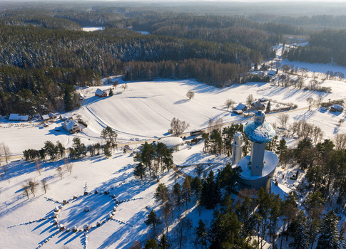 Aerial view of Lithuanian Museum of Ethnocosmology with its futuristic tower and glass dome overlooking snow covered fields and pine forests in Kulionys Utenos apskritis Lithuania.