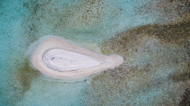 Aerial view of Los Roques archipelago featuring a small white sand cay surrounded by turquoise shallow waters and coral reefs in Los Roques Dependencias Federale Venezuela. Aerial view of Los Roques archipelago featuring a small white sand cay surrounded by turquoise shallow waters and coral reefs in Los Roques Dependencias Federale Venezuela.