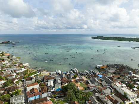 Aerial view of the coastal village where houses meet the turquoise sea a vibrant contrast under the expansive sky Karimunjawa Central Java Indonesia. Aerial view of the coastal village where houses meet the turquoise sea a vibrant contrast under the expansive sky Karimunjawa Central Java Indonesia.