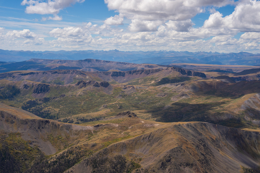 View of the rugged San Juan Mountains landscape near San Luis Peak featuring expansive ridges deep valleys and rocky terrain under a bright sky in Creede Colorado United States. View of the rugged San Juan Mountains landscape near San Luis Peak featuring expansive ridges deep valleys and rocky terrain under a bright sky in Creede Colorado United States.