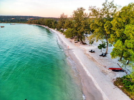 Aerial view of turquoise waters meet the pristine white sands fringed by verdant trees creating a serene coastal haven Preah Sihanouk Sihanoukville Cambodia.