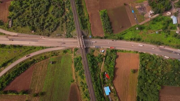Aerial view of highway overpass and railway tracks in India.