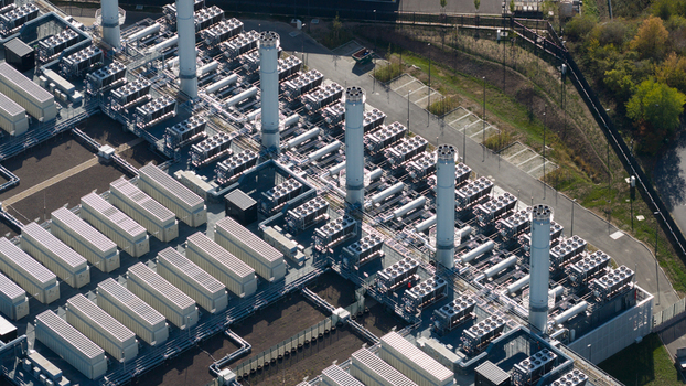Aerial view of a large industrial power facility with cooling towers rows of electrical equipment and storage units in Dietzenbach Hessen Germany. Aerial view of a large industrial power facility with cooling towers rows of electrical equipment and storage units in Dietzenbach Hessen Germany.