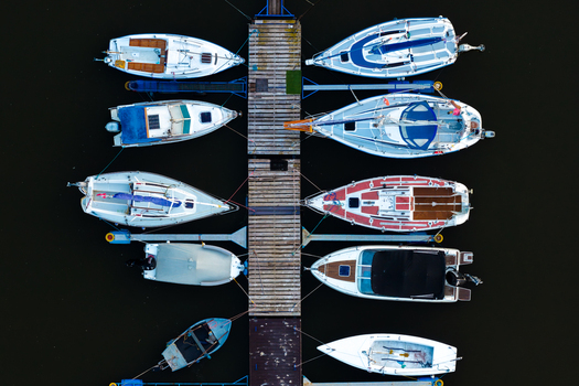 Aerial view of various sailboats and motorboats moored at a wooden pier in the marina in Plock Masovian Voivodeship Poland. Aerial view of various sailboats and motorboats moored at a wooden pier in the marina in Plock Masovian Voivodeship Poland.