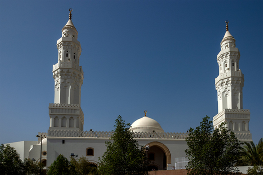 View of the white minarets and dome of the historic Masjid Quba mosque set against a clear blue sky in Madinah Al Madinah Province Saudi Arabia.
