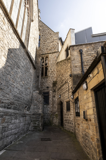 View of a narrow historic stone alleyway between ancient buildings in Durham England United Kingdom. View of a narrow historic stone alleyway between ancient buildings in Durham England United Kingdom.