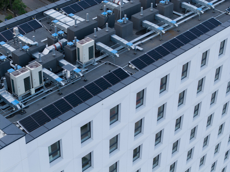 Aerial view of a modern building rooftop featuring solar panels and HVAC ventilation systems in Krakow Lesser Poland Voivode Poland. Aerial view of a modern building rooftop featuring solar panels and HVAC ventilation systems in Krakow Lesser Poland Voivode Poland.