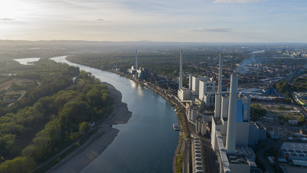 Aerial view of the Grosskraftwerk Mannheim power plant situated along the Rhine river featuring tall chimneys industrial buildings and surrounding greenery in Mannheim Baden Wurttemberg Germany.