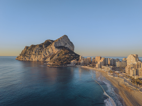 Aerial view of the Penyal d Ifac rock formation rising above the Mediterranean Sea with the sandy beach and modern apartment buildings in Calp Valencian Community Spain. Aerial view of the Penyal d Ifac rock formation rising above the Mediterranean Sea with the sandy beach and modern apartment buildings in Calp Valencian Community Spain.