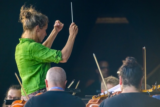 Lisboa Portugal 05 September 2026 View of a female conductor leading an orchestra with musicians playing string instruments in an outdoor setting. Lisboa Portugal 05 September 2026 View of a female conductor leading an orchestra with musicians playing string instruments in an outdoor setting.