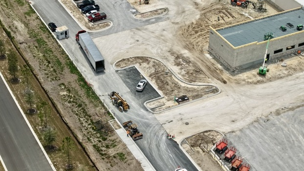 Aerial view of the construction site at Foundry Lane featuring heavy machinery a semi truck and a building under development in World Golf Village Florida United States.
