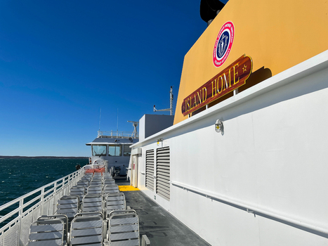 Edgartown United States 14 May 2026 View of the Island Home ferry deck with empty passenger seats and the yellow funnel under a clear blue sky near Martha s Vineyard.
