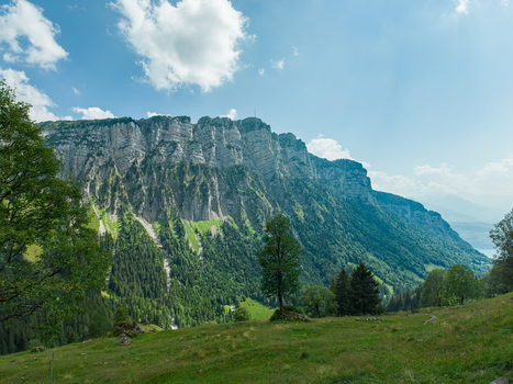 Aerial view of the Justistal valley and the Niederhorn mountain range with lush green slopes dense forests and a glimpse of Lake Thun in Sigriswil Bern Switzerland. Aerial view of the Justistal valley and the Niederhorn mountain range with lush green slopes dense forests and a glimpse of Lake Thun in Sigriswil Bern Switzerland.
