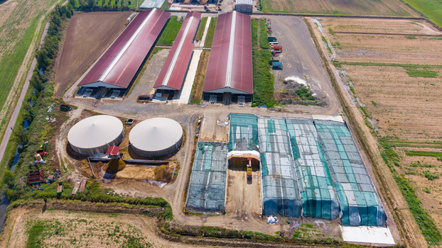 Aerial view of a cattle and dairy farm with large barns biogas storage tanks and covered silage pits in San Giuliano Milanese Lombardy Italy. Aerial view of a cattle and dairy farm with large barns biogas storage tanks and covered silage pits in San Giuliano Milanese Lombardy Italy.