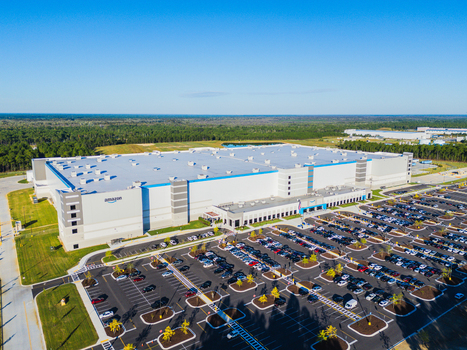 Wilmington United States 27 September 2026 Aerial view of Amazon Robotics Fulfillment Center with its expansive roof large parking lot and surrounding green landscape under a clear sky. Wilmington United States 27 September 2026 Aerial view of Amazon Robotics Fulfillment Center with its expansive roof large parking lot and surrounding green landscape under a clear sky.
