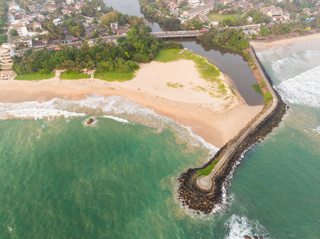 Aerial view of View Point Mahamodara fishing spot with its stone breakwater sandy beach and river mouth meeting the ocean Galle Sri Lanka. Aerial view of View Point Mahamodara fishing spot with its stone breakwater sandy beach and river mouth meeting the ocean Galle Sri Lanka.