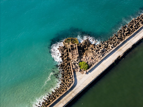 Aerial view of the Rio Ozama breakwater featuring concrete tetrapods turquoise Caribbean Sea waters and a concrete pier in Santo Domingo Santo Domingo Dominican Republic.