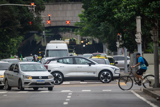 Rio de Janeiro Brazil 13 June 2026 View of traffic on a busy urban street with cars a cyclist and a tunnel entrance surrounded by lush trees.