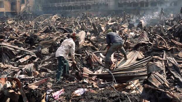 View of workers amidst charred debris after a fire Bangladesh. View of workers amidst charred debris after a fire Bangladesh.