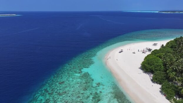 Aerial view of the white sand beach and coral reef of Kamadhoo island Maldives. Aerial view of the white sand beach and coral reef of Kamadhoo island Maldives.