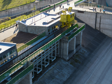 Aerial view of the Czorsztyn Dam with its distinctive yellow crane structure concrete walkways and green railings Niedzica Malopolskie Poland.