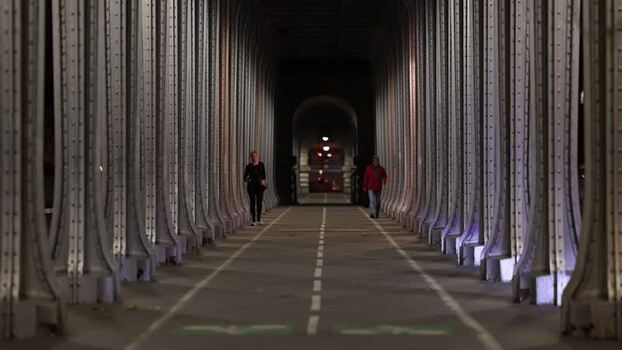 View of people walking on the Pont de Bir Hakeim at night France.