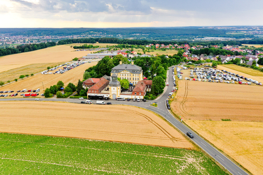 Aerial view of Schloss Jagersburg surrounded by lush green fields and trees under a cloudy sky in Eggolsheim Bayern Germany. Aerial view of Schloss Jagersburg surrounded by lush green fields and trees under a cloudy sky in Eggolsheim Bayern Germany.