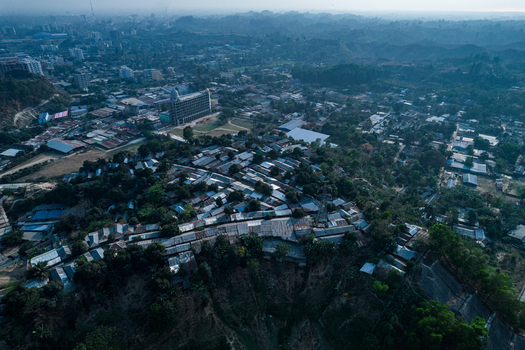 Chittagong Bangladesh 10 March 2022 Aerial view of dense housing on hilly terrain showing small metal roofed homes trees and steep slopes prone to landslides.